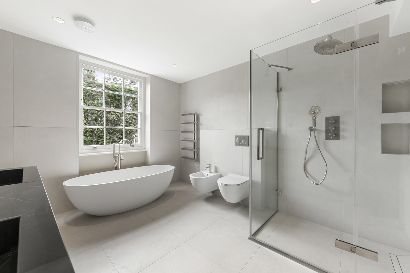 Bathroom at Brompton Square with a freestanding bath and walk-in shower lined in large-format stone