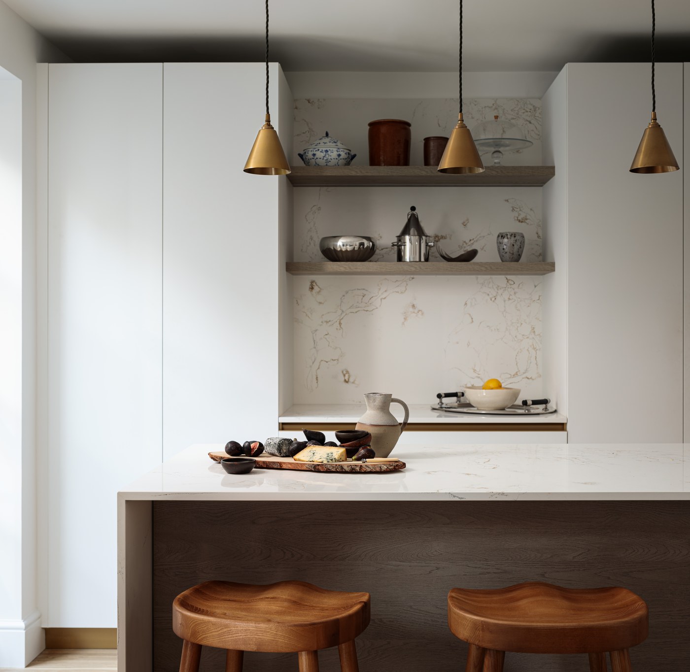 Stone kitchen island and brass pendants at Brompton Square