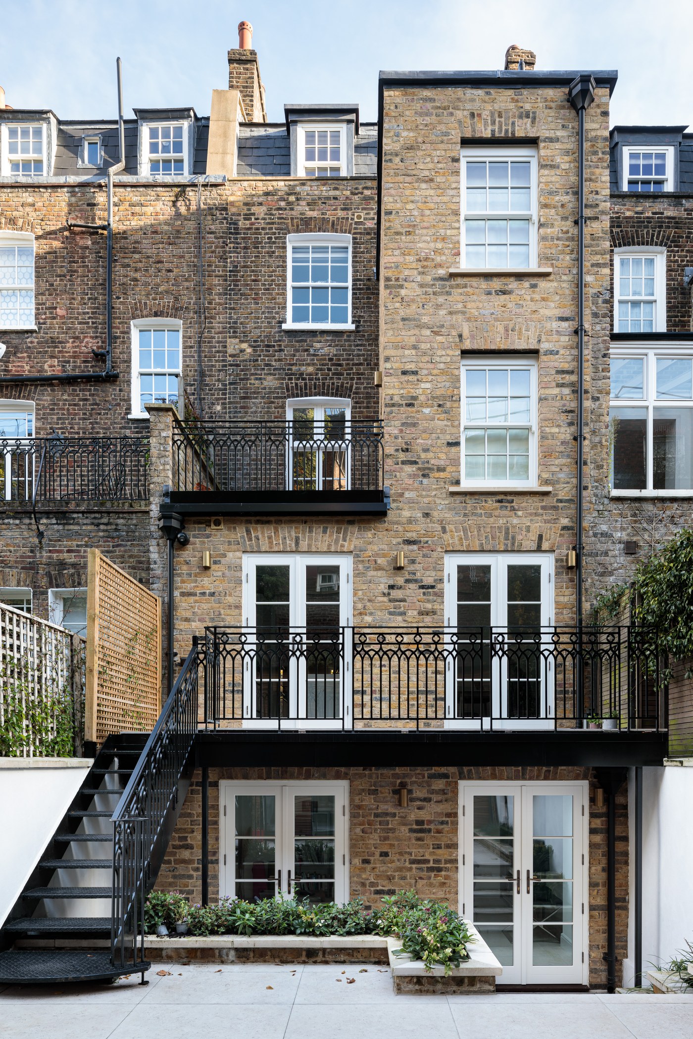 Rear elevation at Brompton Square showing the balcony, replacement sash windows and timber-clad garden building beyond