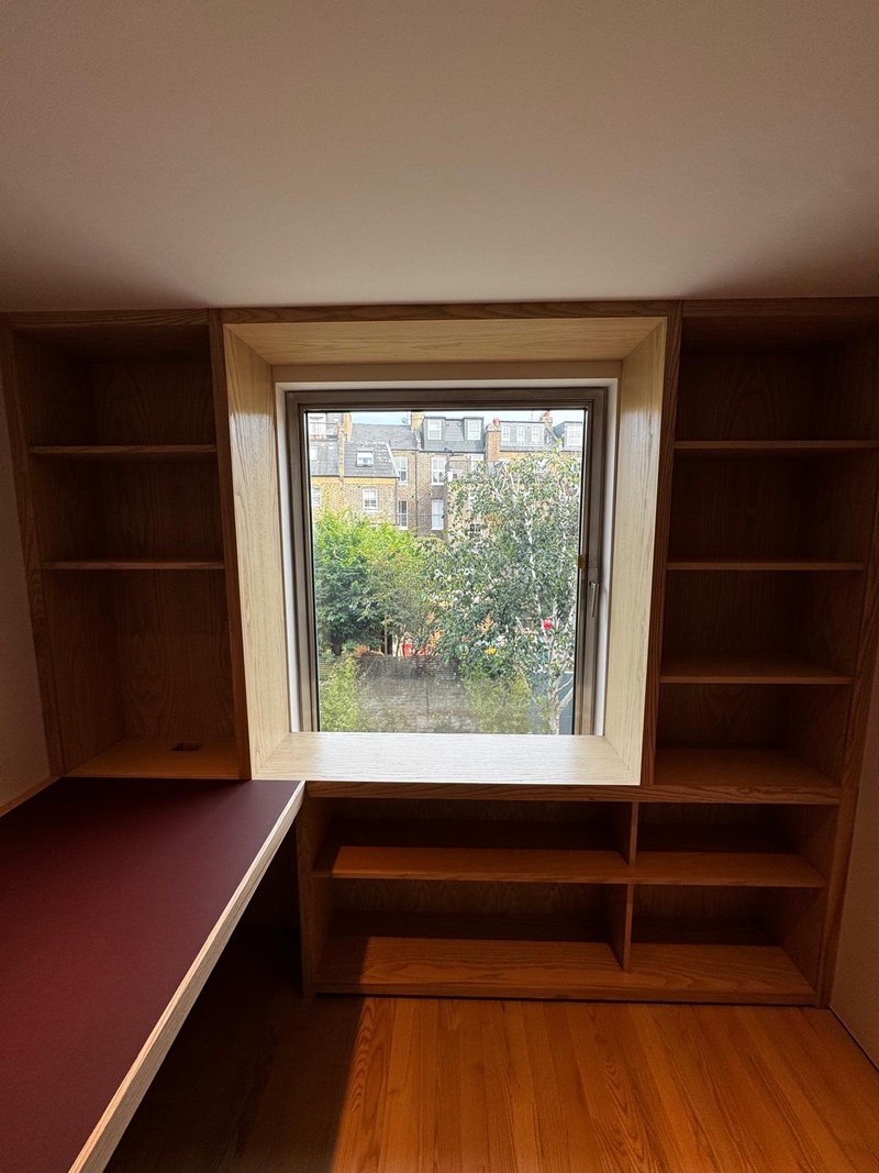 Caithness Road W14 — study with ash shelving built around a deep ash-lined window reveal, and a fitted desk