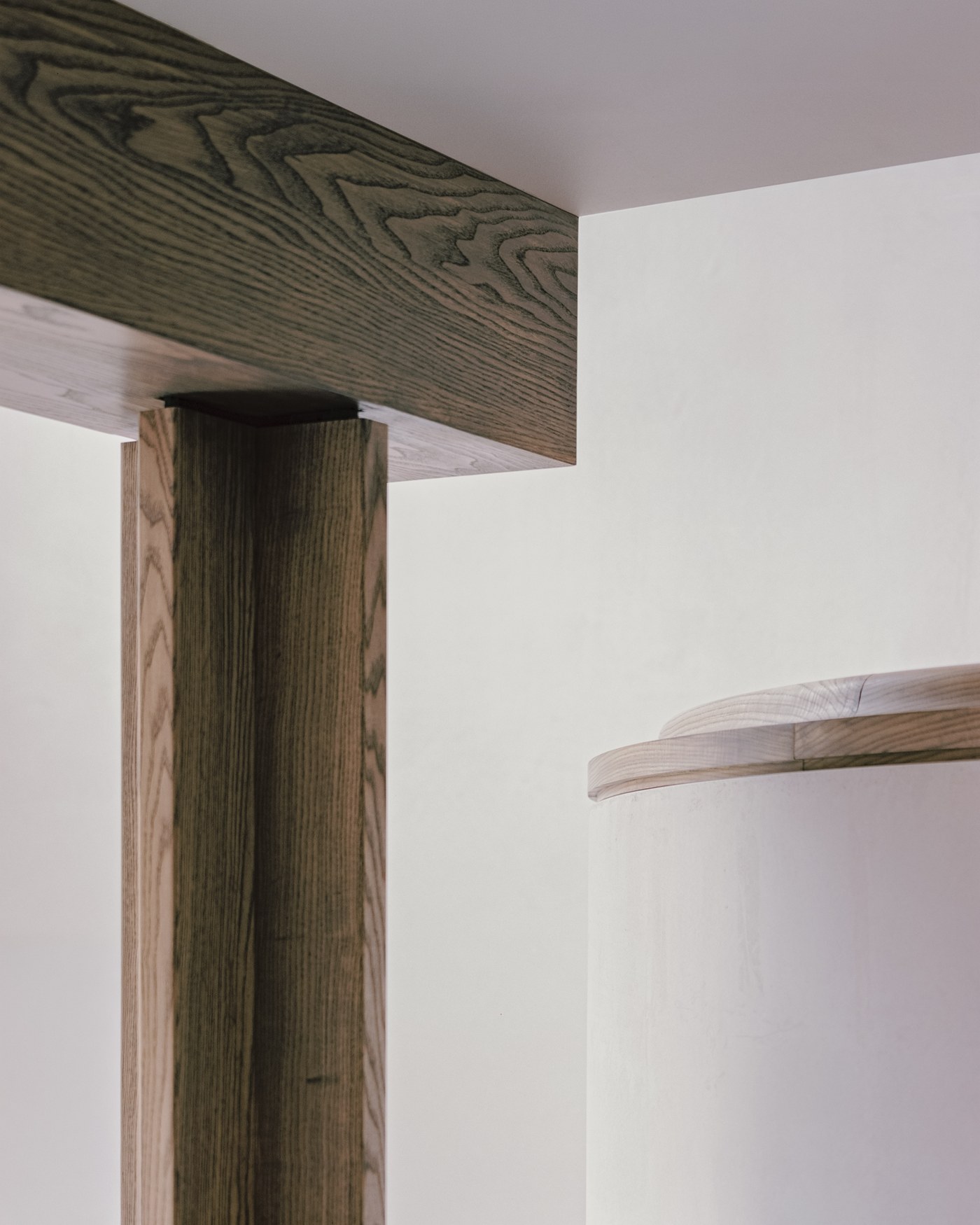 Caithness Road W14 — detail of a timber post meeting the beam above it, beside a curved plastered wall