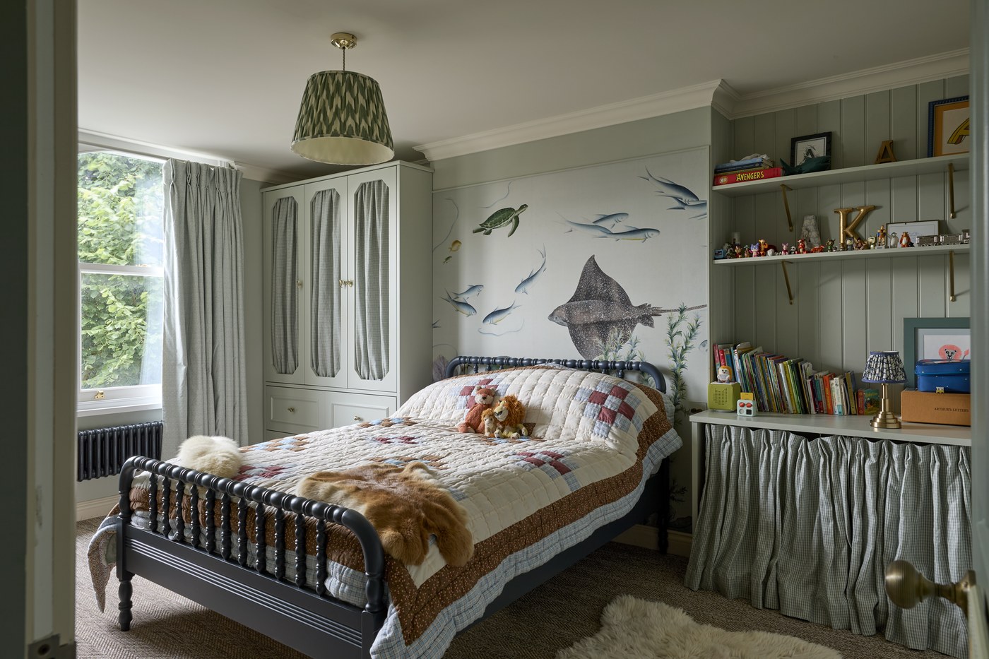 Children's bedroom at Melrose Gardens with papered walls and an iron bedstead