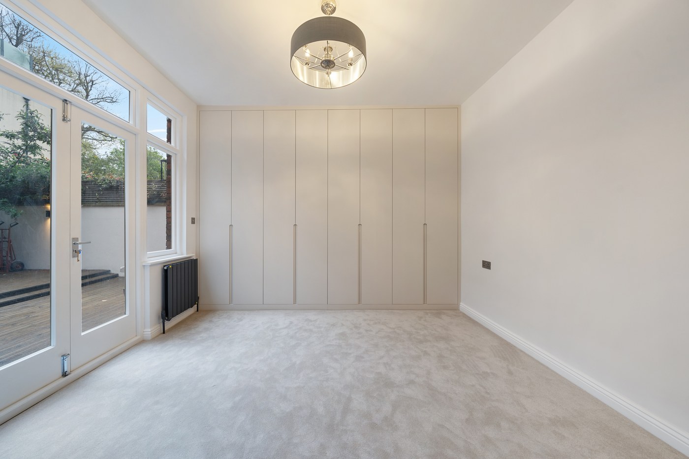 Bedroom at St John's Wood Road with fitted wardrobes and glazed doors to the garden