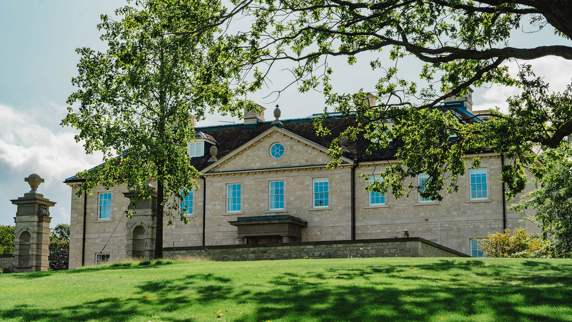Grand country house with stone facade set on landscaped grounds