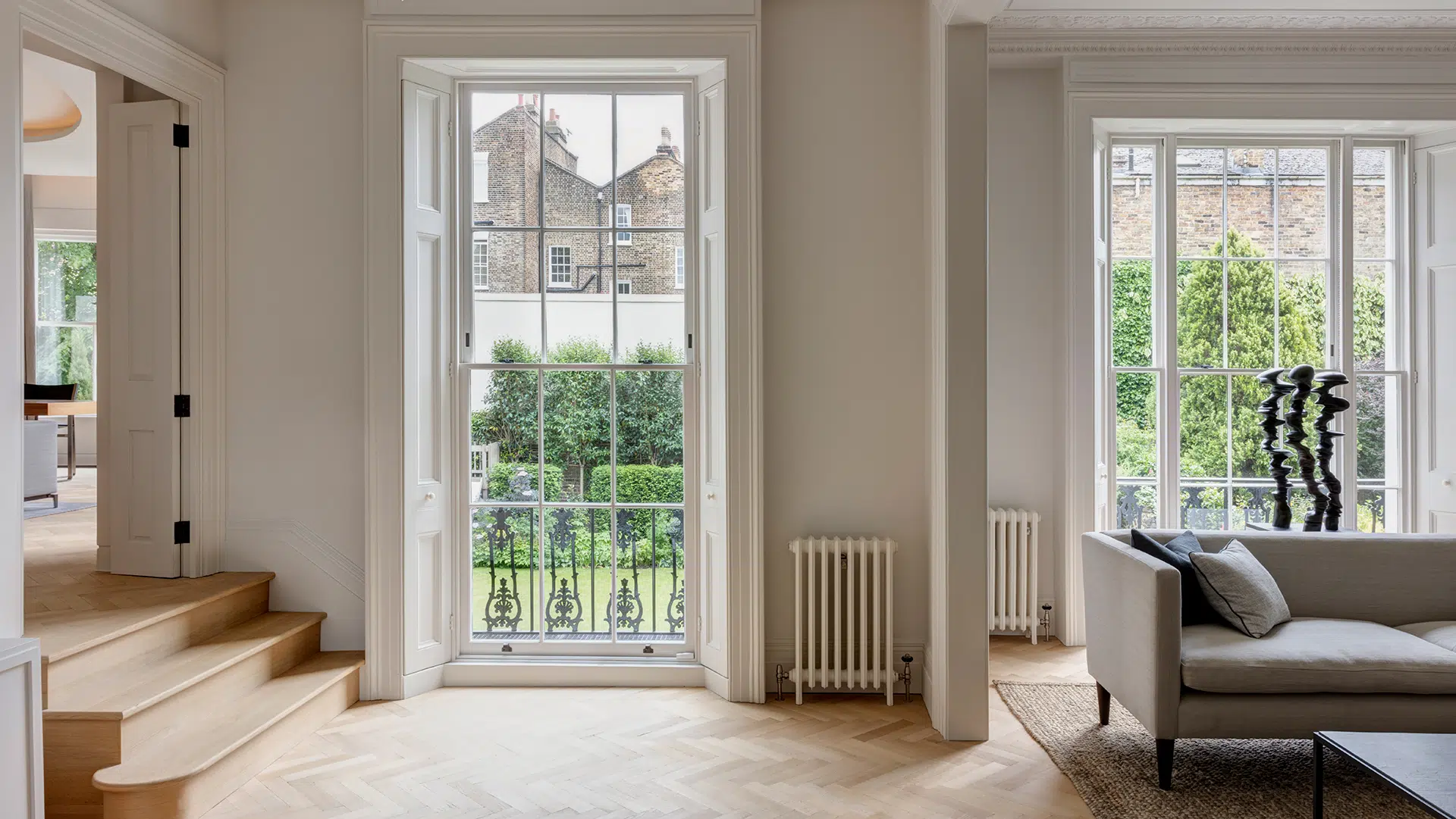 Light filled London townhouse interior with sash windows overlooking the garden
