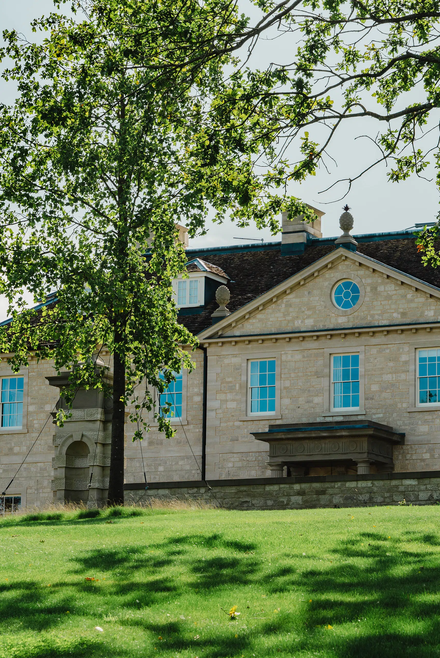 Grand country house with stone facade set on landscaped grounds