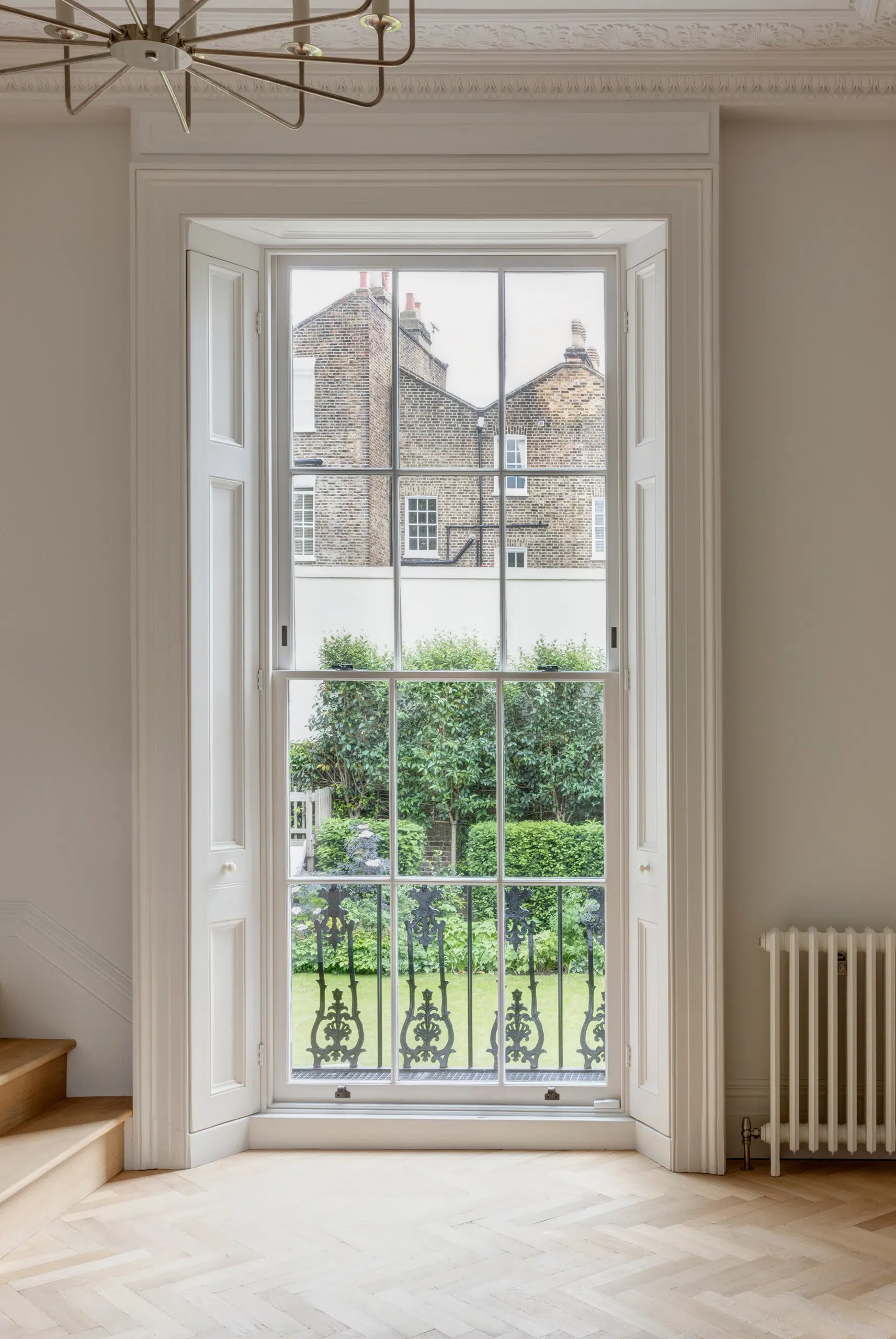Light filled London townhouse interior with sash windows overlooking the garden